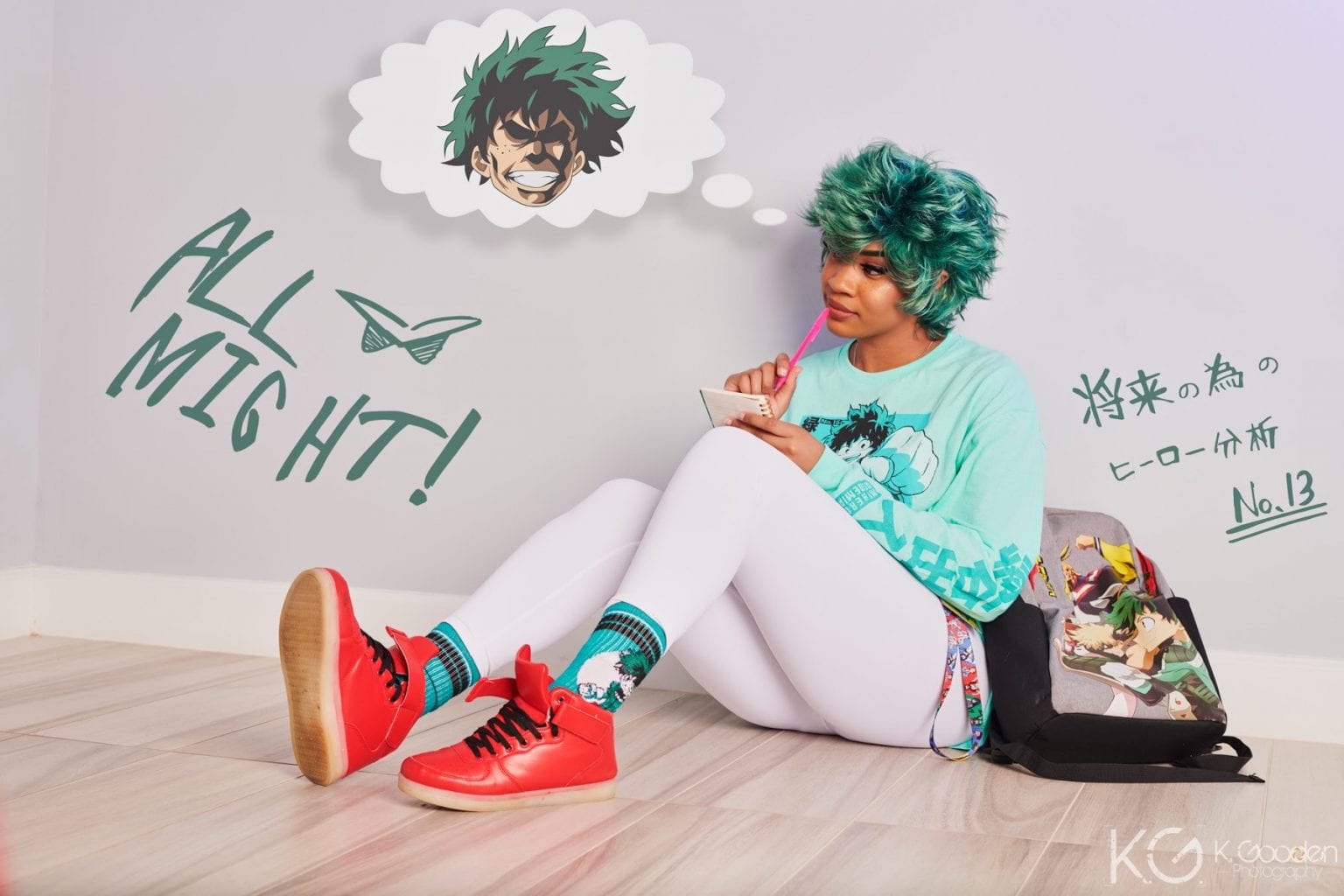 BCC dressed as Deku from My Hero Academia with a teal hoodie, white leggings, red shoes and teal wig. sitting down dreaming of being a buff super