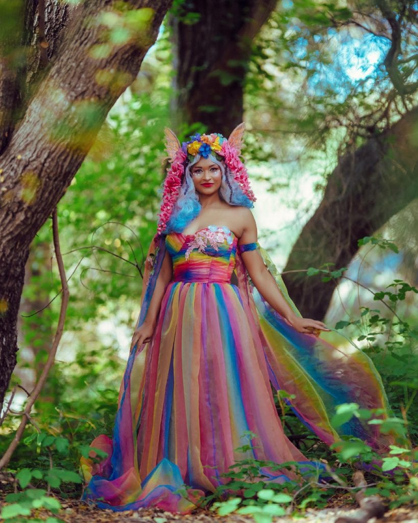 fae inspired by the rainbow. floral head dress, rainbow dress, pastel purple blue hair